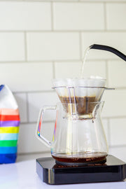 Photo of a kettle pouring water into a pour-over device.