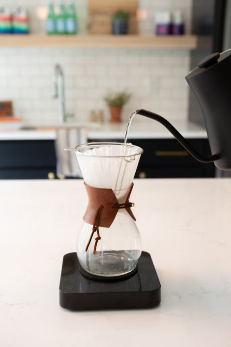 Photo of a kettle pouring water into a chemex on a scale.