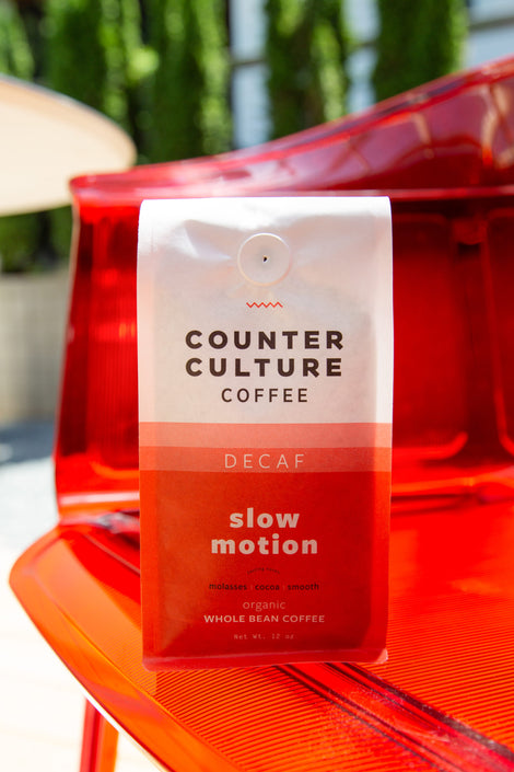 Photo of a bag of decaf Slow Motion coffee on a chair.