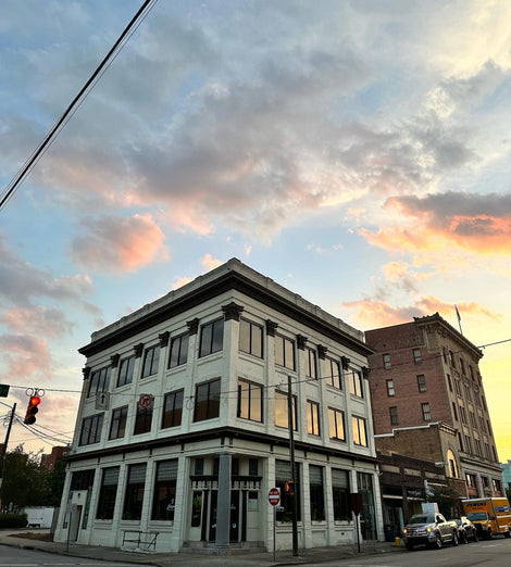 Outside image of Larema Coffee House. It's a corner building and there is a sunset in the background.